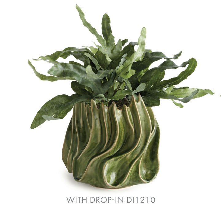 Sylva medium green ceramic vase styled with a leafy fern drop-in above its flowing curves on a pale backdrop. Modern Organic