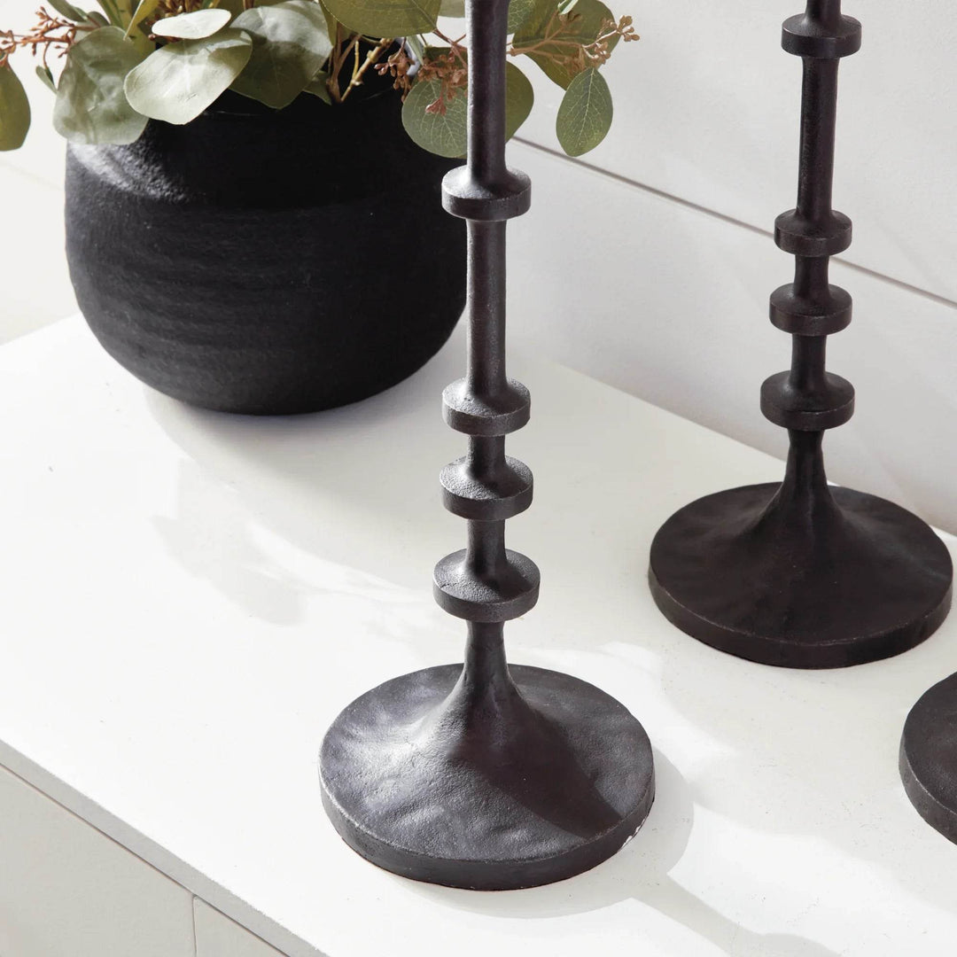 Close-up of notched detailing and textured finish on tall industrial black bronze candle holder column – Industrial