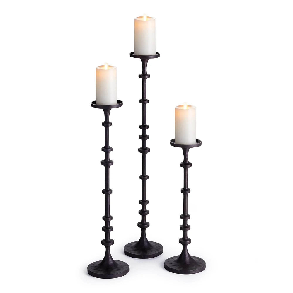 Trio of tall industrial black bronze candle holders shown with white pillar candles in graduated heights – Transitional Decor