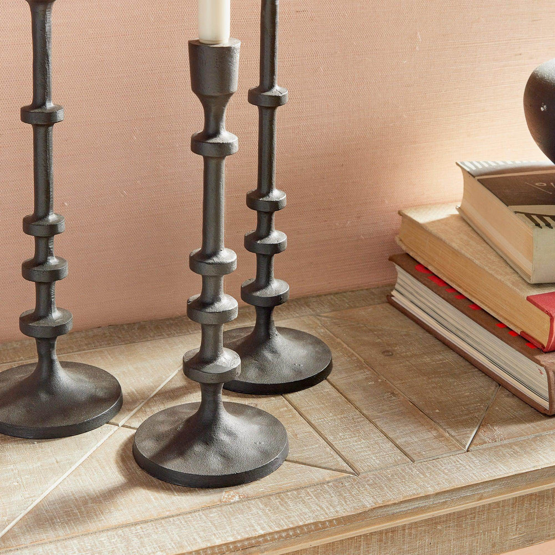 Close up of bronze taper candle holder bases with industrial notched design