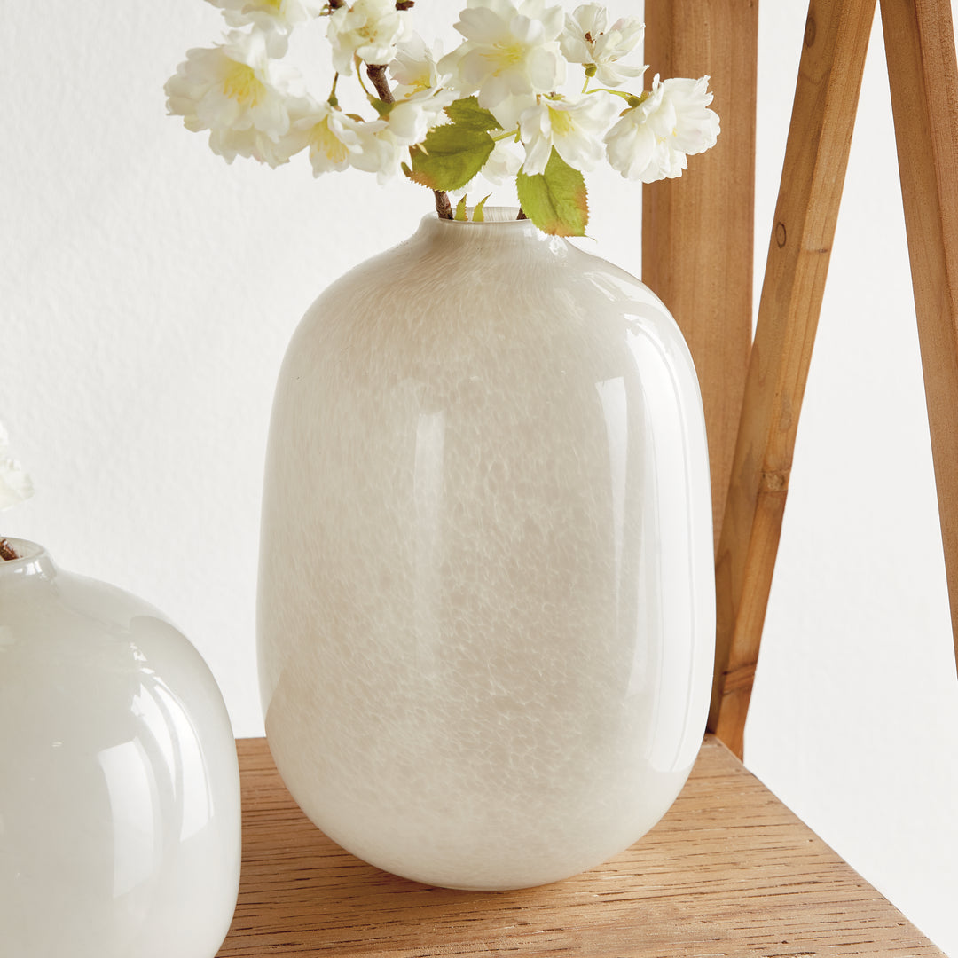 Tall Ivory glass vase with decorative flowers on wood console, beside a lower rounded companion vessel, Modern Organic style