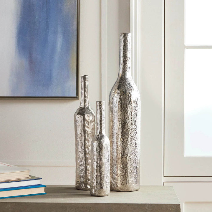 Tall silver hammered aluminum vase paired with smaller vase on console for layered modern classic styling.

