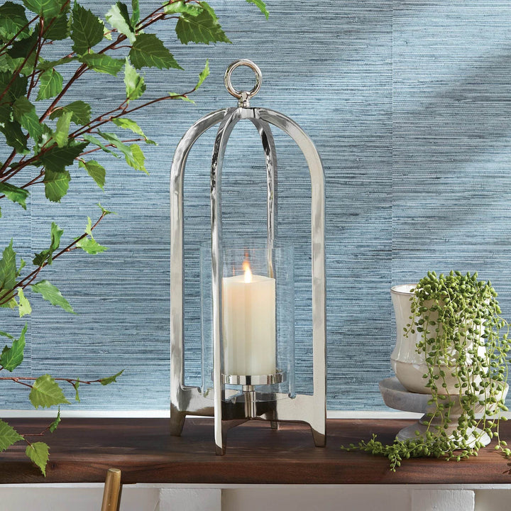 Silver hurricane lantern with LED candle on wood mantel, styled with plants and ceramics – Modern Classic

