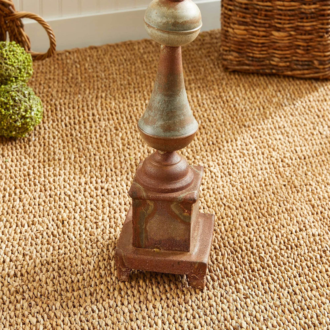 Close-up of base of tall weathered metal decorative finial showing antique galvanized texture, iron decor accent for home – Vintage Farmhouse.

