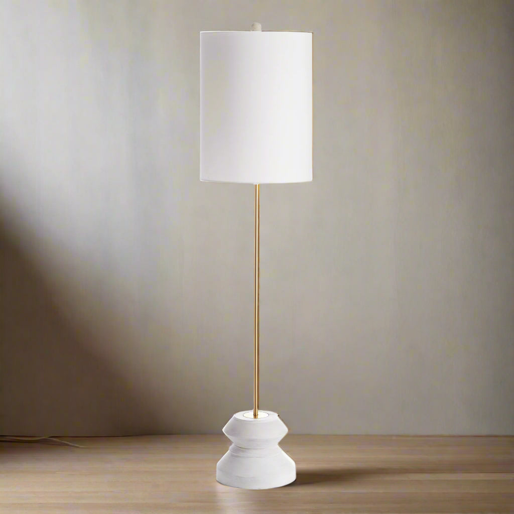 Modern rustic table lamp with linen drum shade and turned wood base, styled against neutral wall