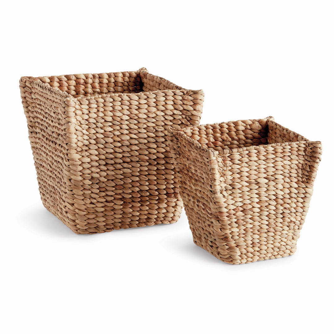 Tamsin tapered water hyacinth baskets in two sizes with open square tops and natural tan woven sides on a background. Coastal