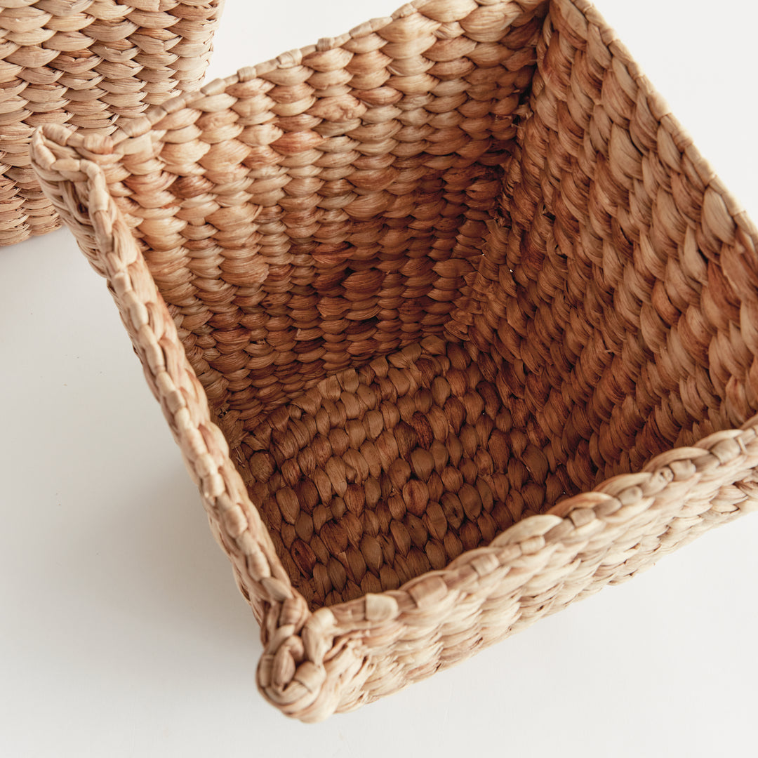 Interior view of Tamsin square basket showing its thick tan woven walls, corner structure and water hyacinth base. Coastal
