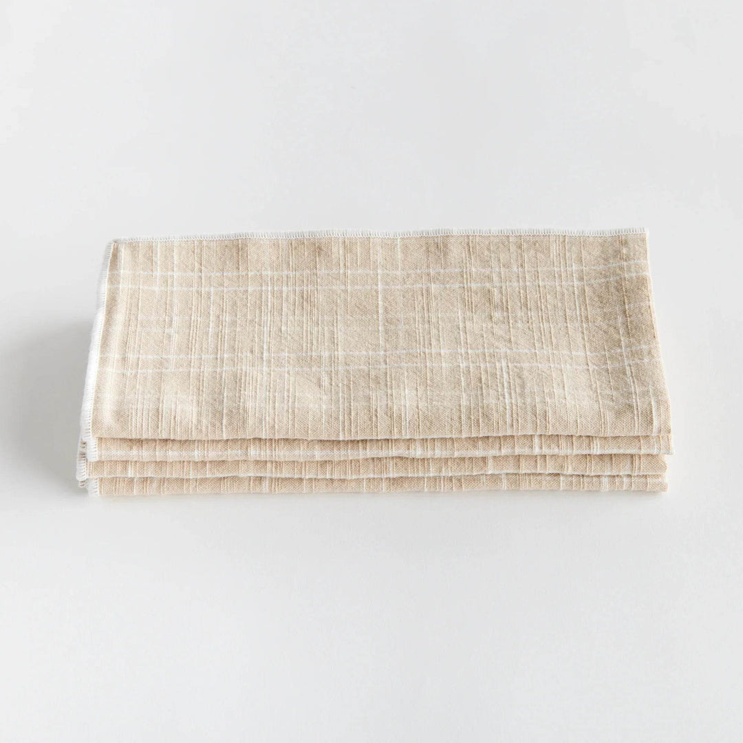 Folded taupe cotton dinner napkin highlights arch grid weave and stitched border for everyday table use - Modern Organic.