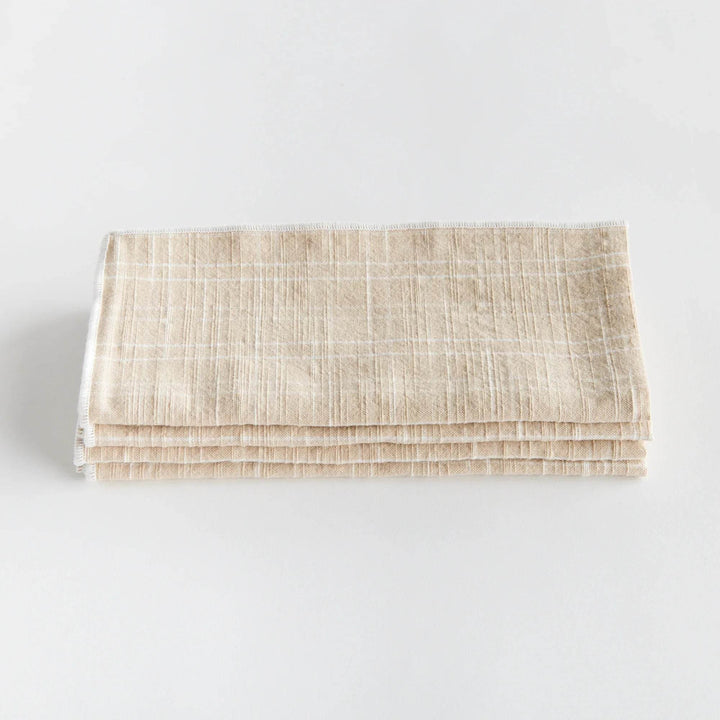 Folded taupe cotton dinner napkin highlights arch grid weave and stitched border for everyday table use - Modern Organic.