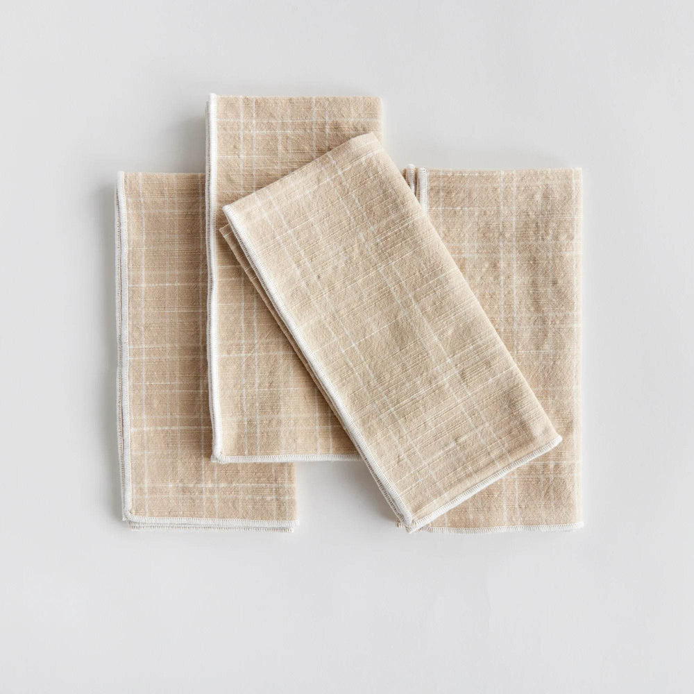 Set of four taupe cotton dinner napkins folded flat to show arch grid pattern and stitched edges, reusable - Modern Organic.