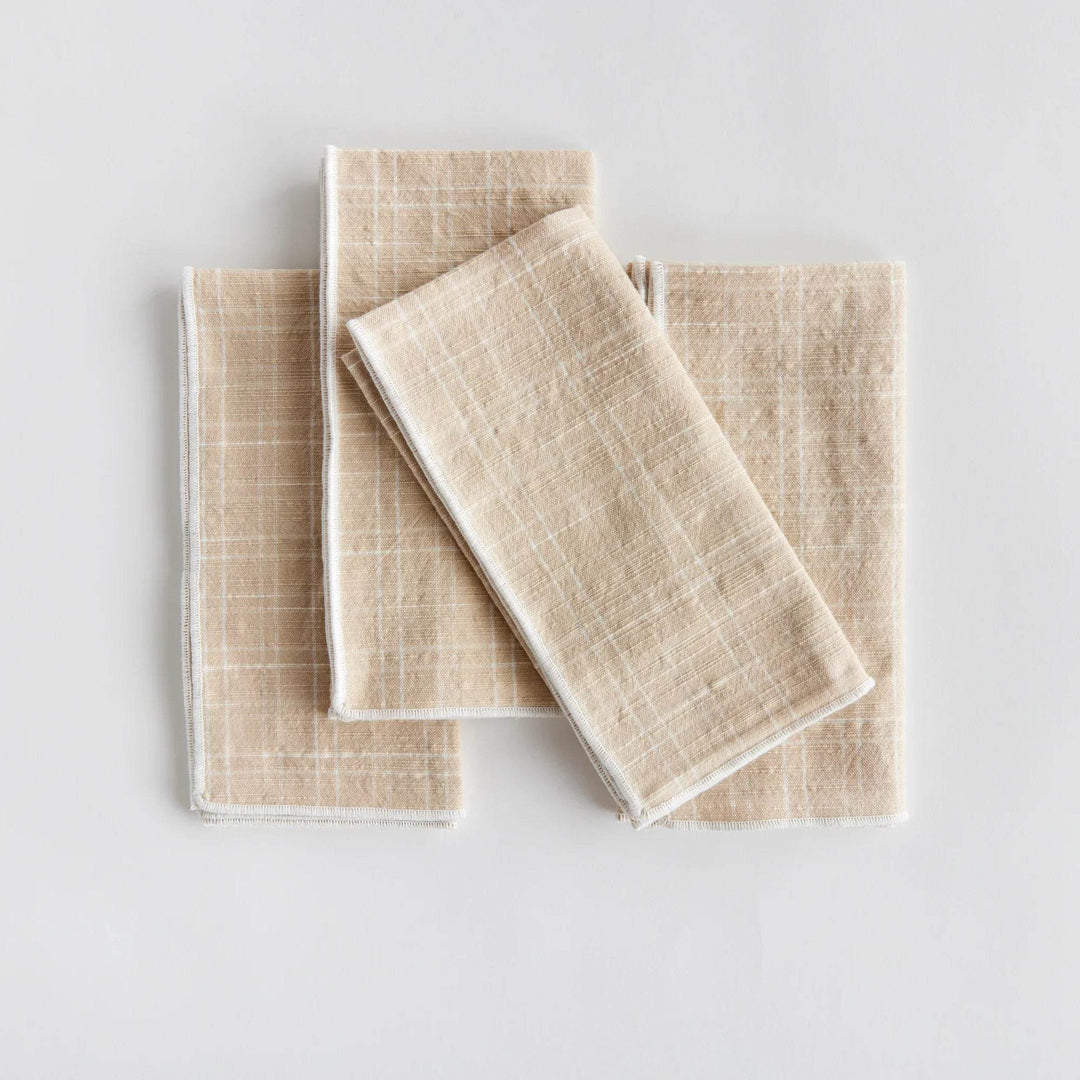Set of four taupe cotton dinner napkins folded flat to show arch grid pattern and stitched edges, reusable - Modern Organic.