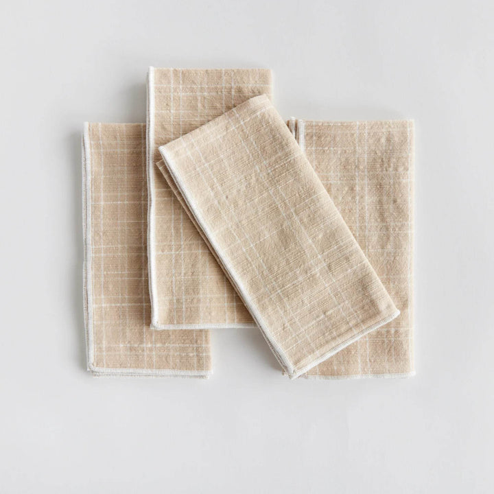 Set of four taupe cotton dinner napkins folded flat to show arch grid pattern and stitched edges, reusable - Modern Organic.