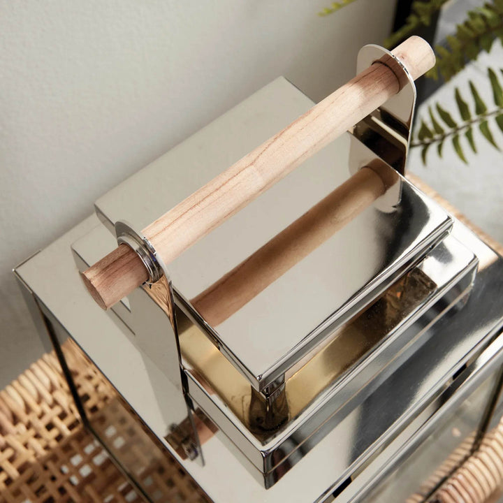 Detailed close-up of teak wood handle on polished silver lantern