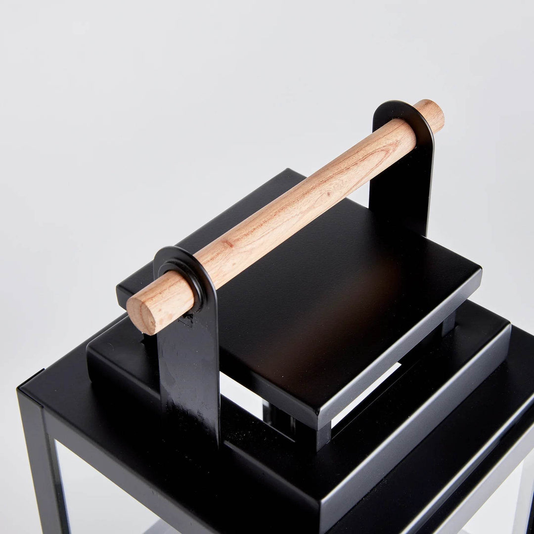 Close up of teak handle on small black outdoor lantern