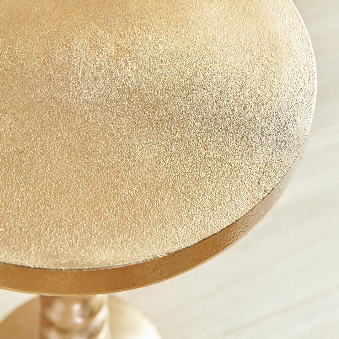 Close-up of hammered brass tabletop with matte-gloss texture in modern glam finish.