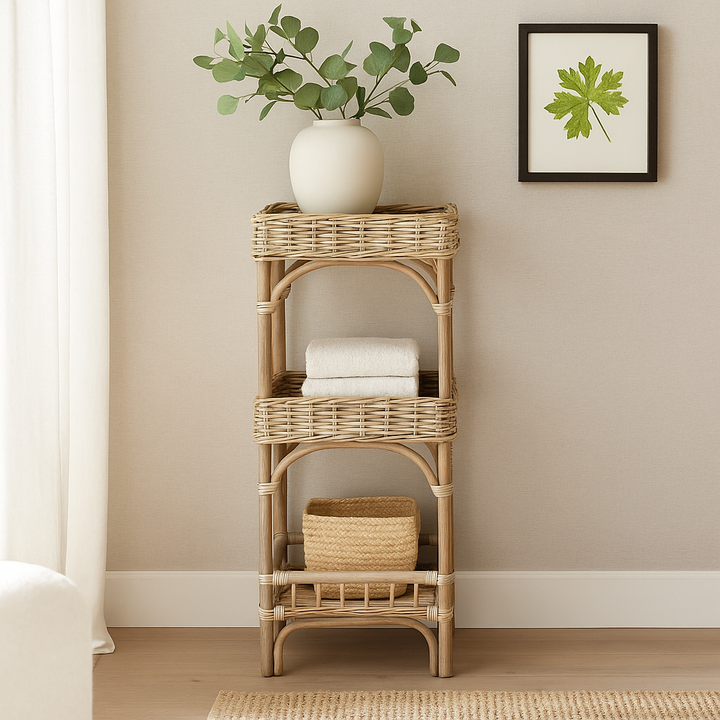 Three-tier wicker shelf styled in a coastal boho interior with soft natural lighting and textured panel walls.







