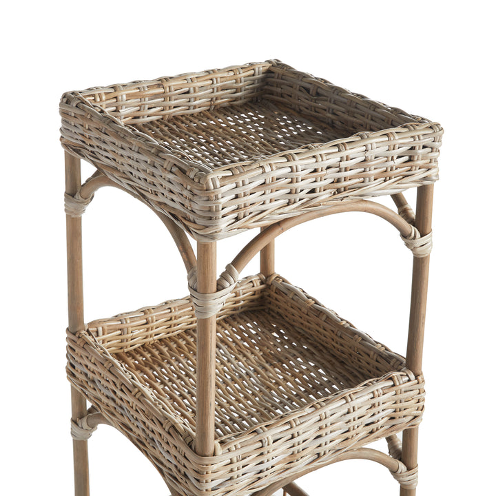 Detailed view of top two woven baskets on natural rattan shelving unit in a coastal boho finish.