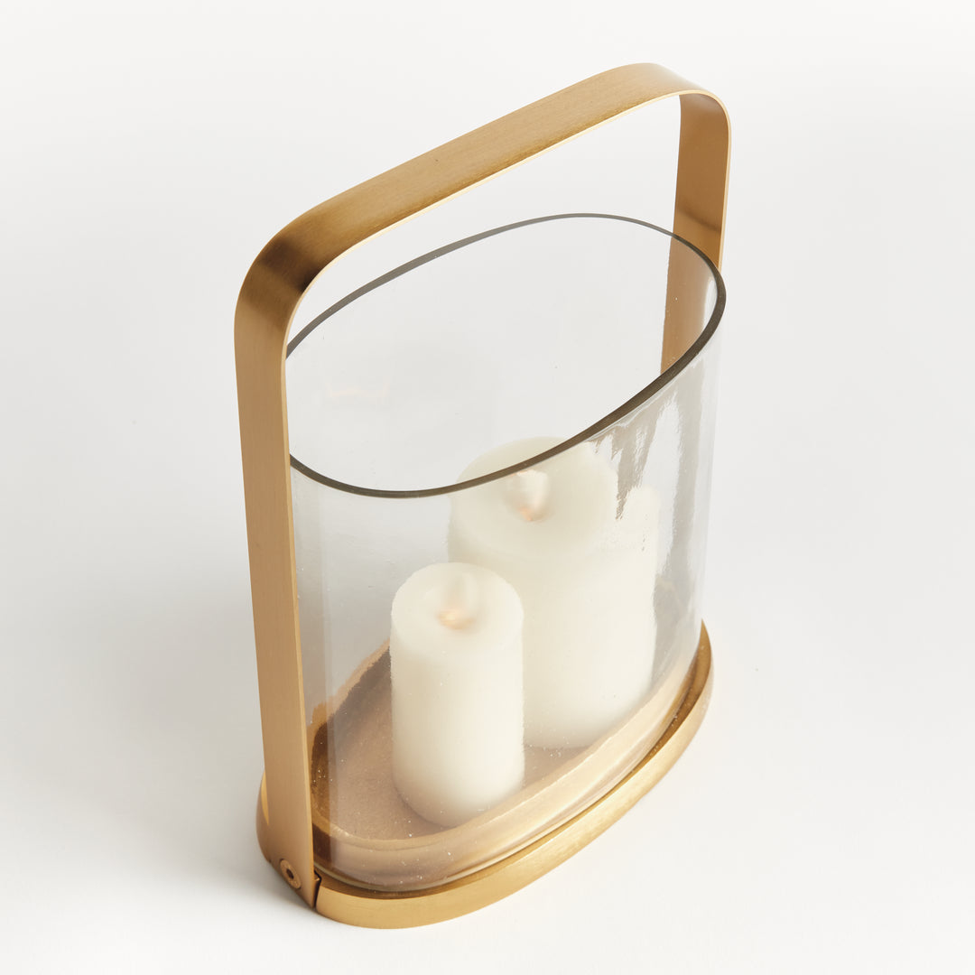 Side angle of the small transitional brass and glass hurricane candle holder with cylindrical glass and brass frame.