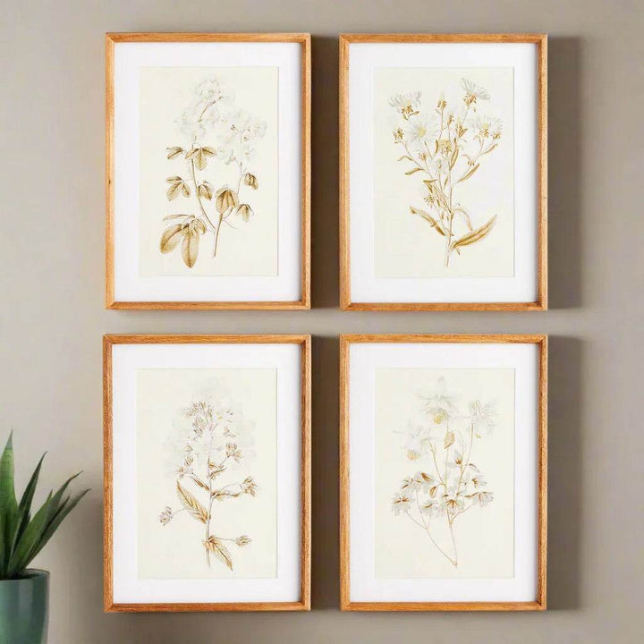 Sepia-toned vintage botanical wall art in a styled room setting, arranged gallery-style with natural wood frames.
