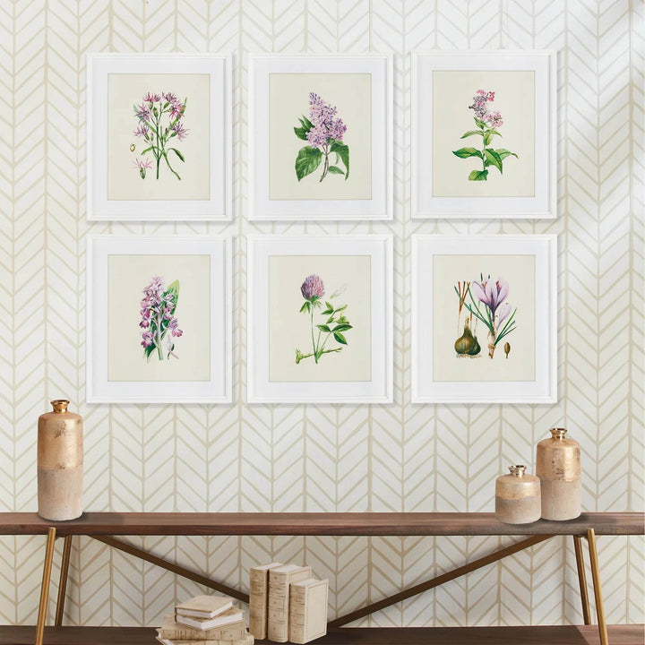 Vintage botanical wall art set with soft green and purple florals styled above console table and gold vases.