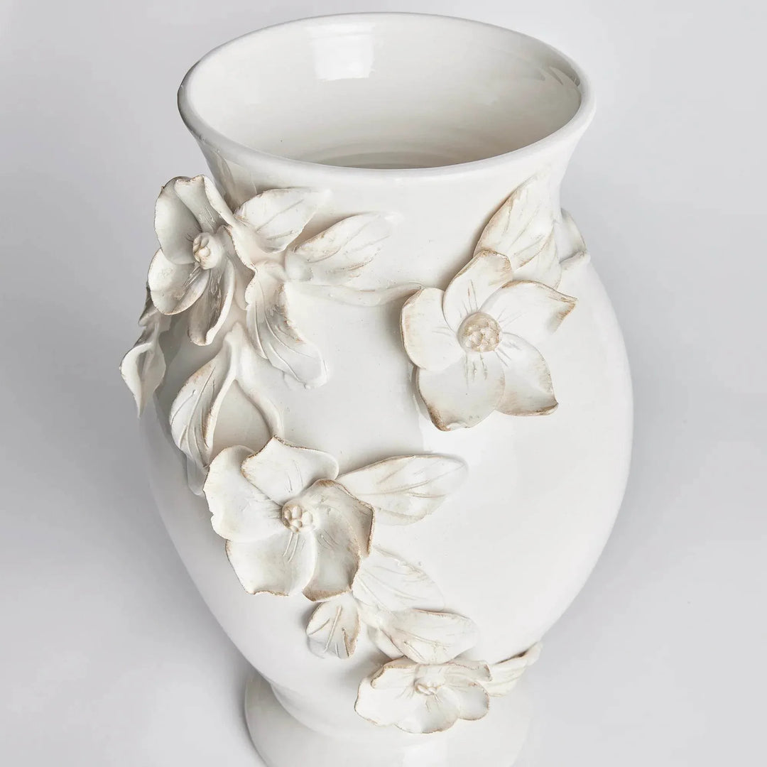 Angled view of a white ceramic vase showing the open neck and hand-applied dogwood flowers and leaves in Traditional style