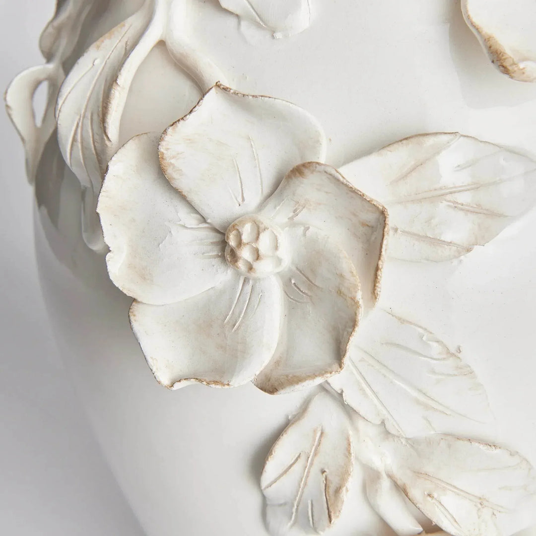 Close view of raised dogwood flowers and leaves on white ceramic vase, with softly antiqued petal edges in Traditional style