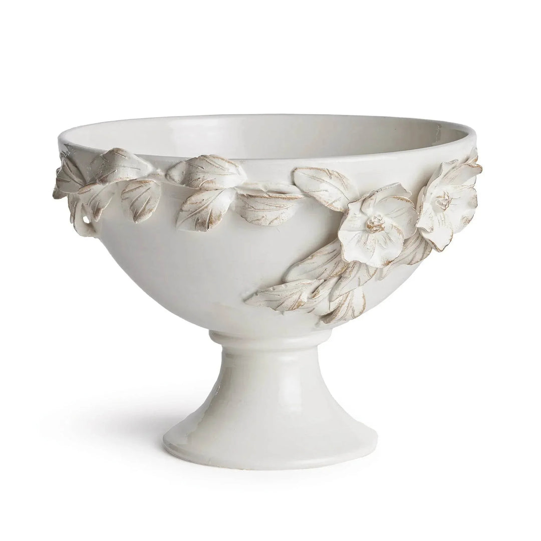 White ceramic footed bowl with raised dogwood flowers and leaves around its curved sides, shown alone in Traditional style