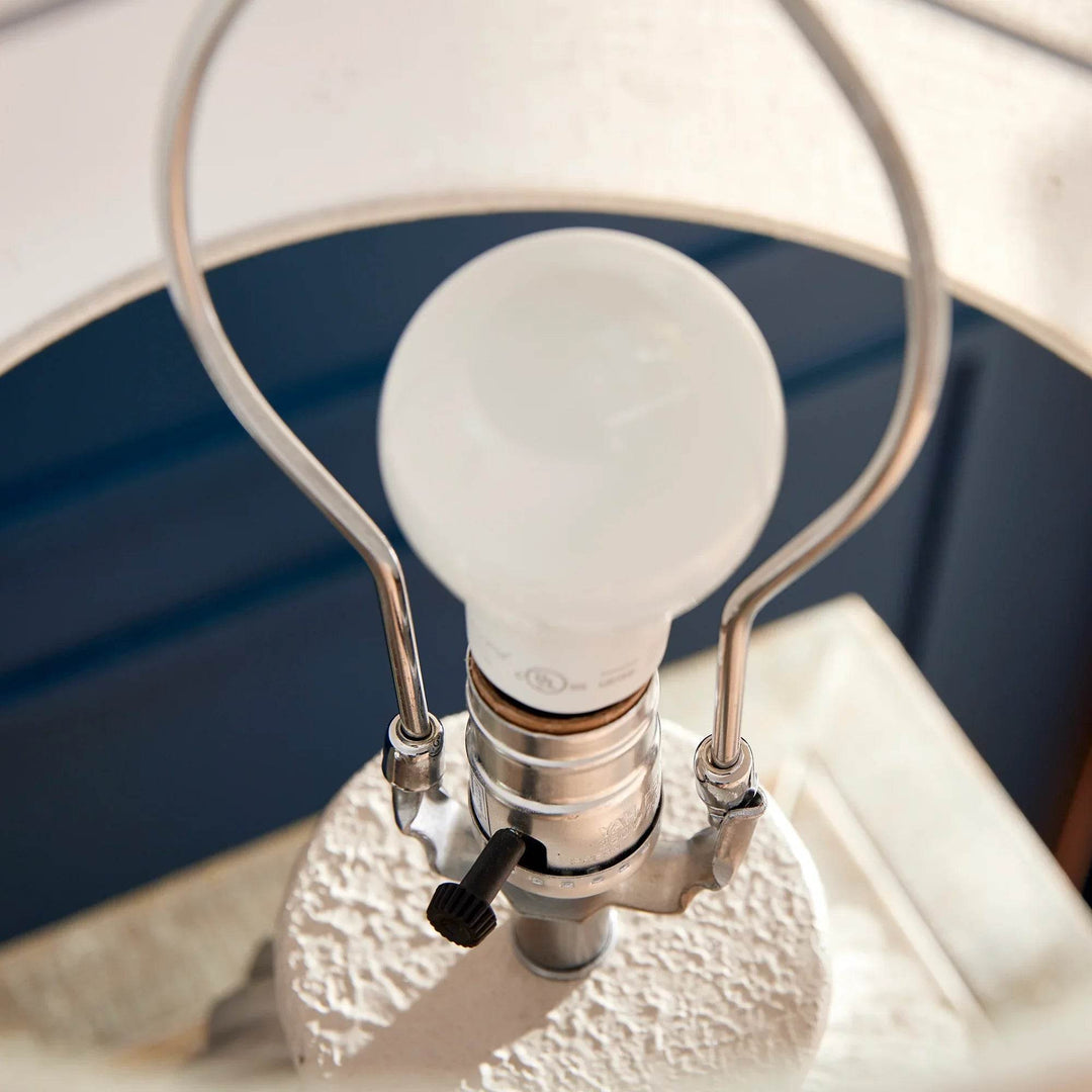View of lamp harp and socket assembly with wooden finial and silver hardware on handcrafted wabi sabi table lamp