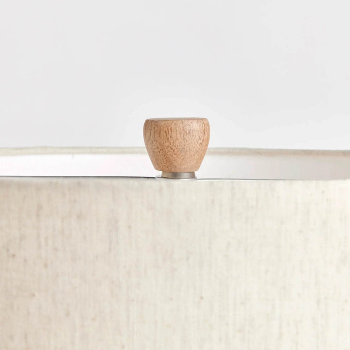 Close-up of wooden finial and linen shade top edge from right angle on wabi sabi style table lamp