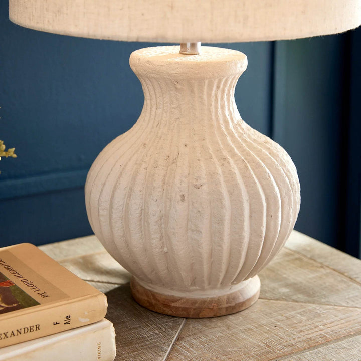 Detail view of wooden base supporting ribbed eco-mix lamp in warm cream finish with visible handcrafted texture