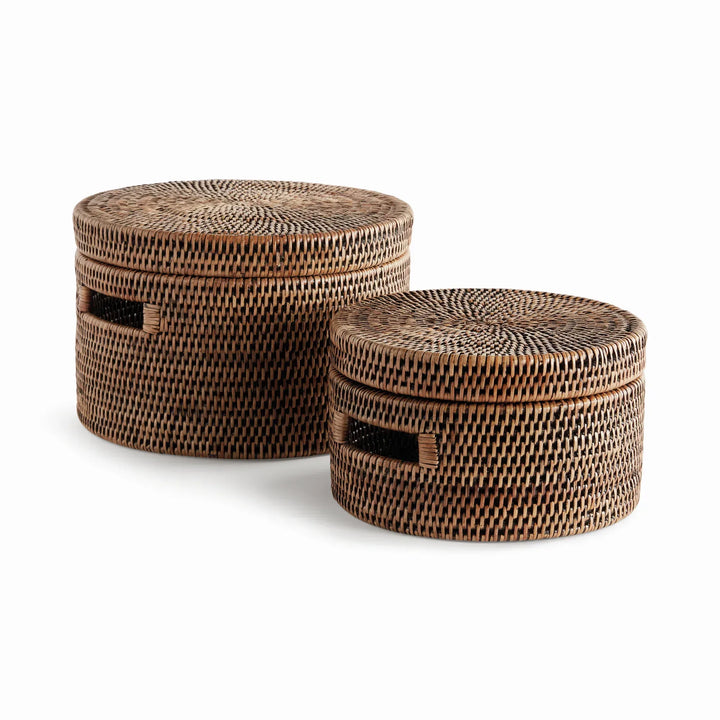Two warm brown handwoven rattan round lidded boxes with cutout handles, shown as a graduated set on plain white, Traditional