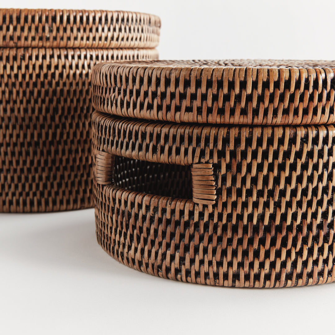 Close view of warm brown rattan boxes showing the tight weave, fitted lid edges and rectangular cutout handle, Traditional