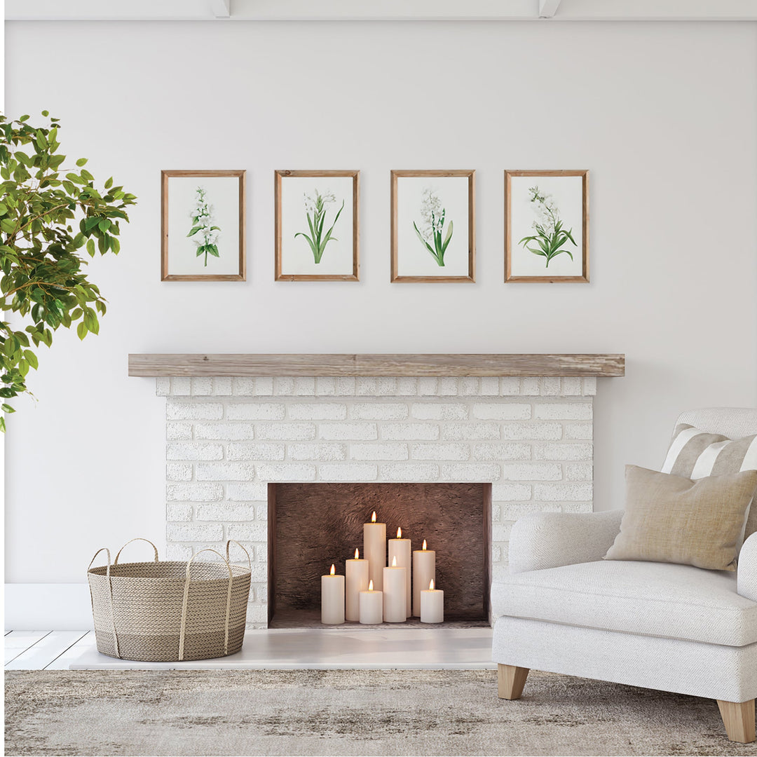 Four framed botanical art prints styled above a whitewashed fireplace in a coastal farmhouse living room