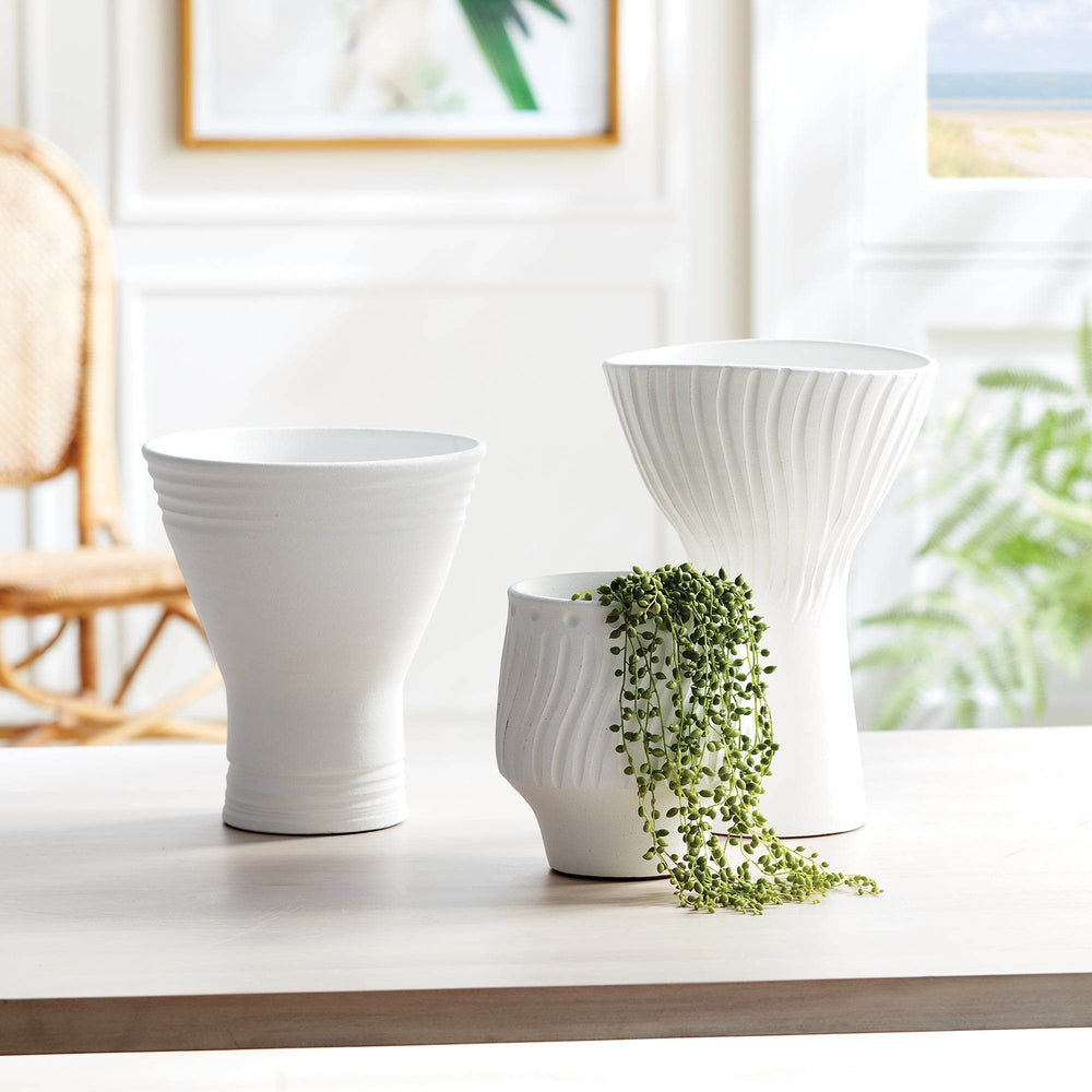 Group of matte white ceramic vases and cachepot on table, showcasing scale and pairing options for modern shelf decor – Modern Organic.

