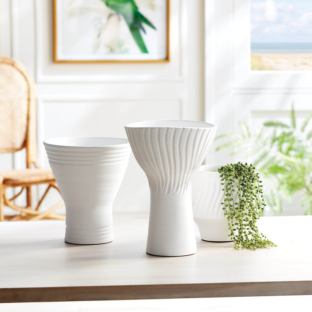 Matte white ceramic cachepot shown with two coordinating vases in sunlit interior setting with natural light – Modern Organic.

