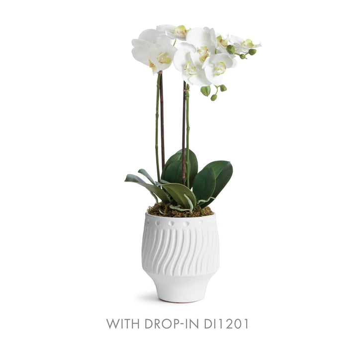 White ceramic cachepot holding faux orchid drop-in, ideal for tabletop styling with clean white matte texture – Modern Organic.

