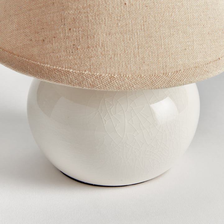 White ceramic mini table lamp close-up showing crackle glaze and the lower edge of its linen shade - Coastal Transitional