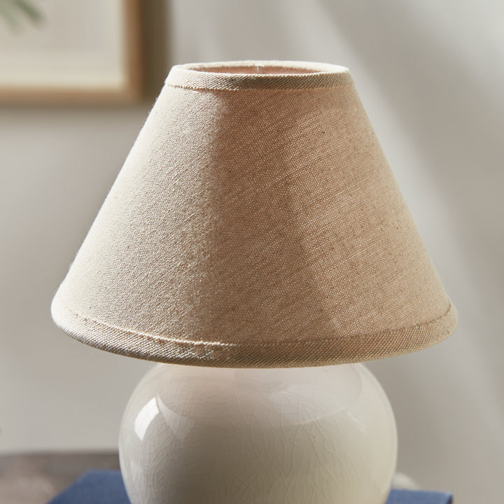 White ceramic mini table lamp detail showing the woven cream linen shade above its glazed round base - Coastal Transitional