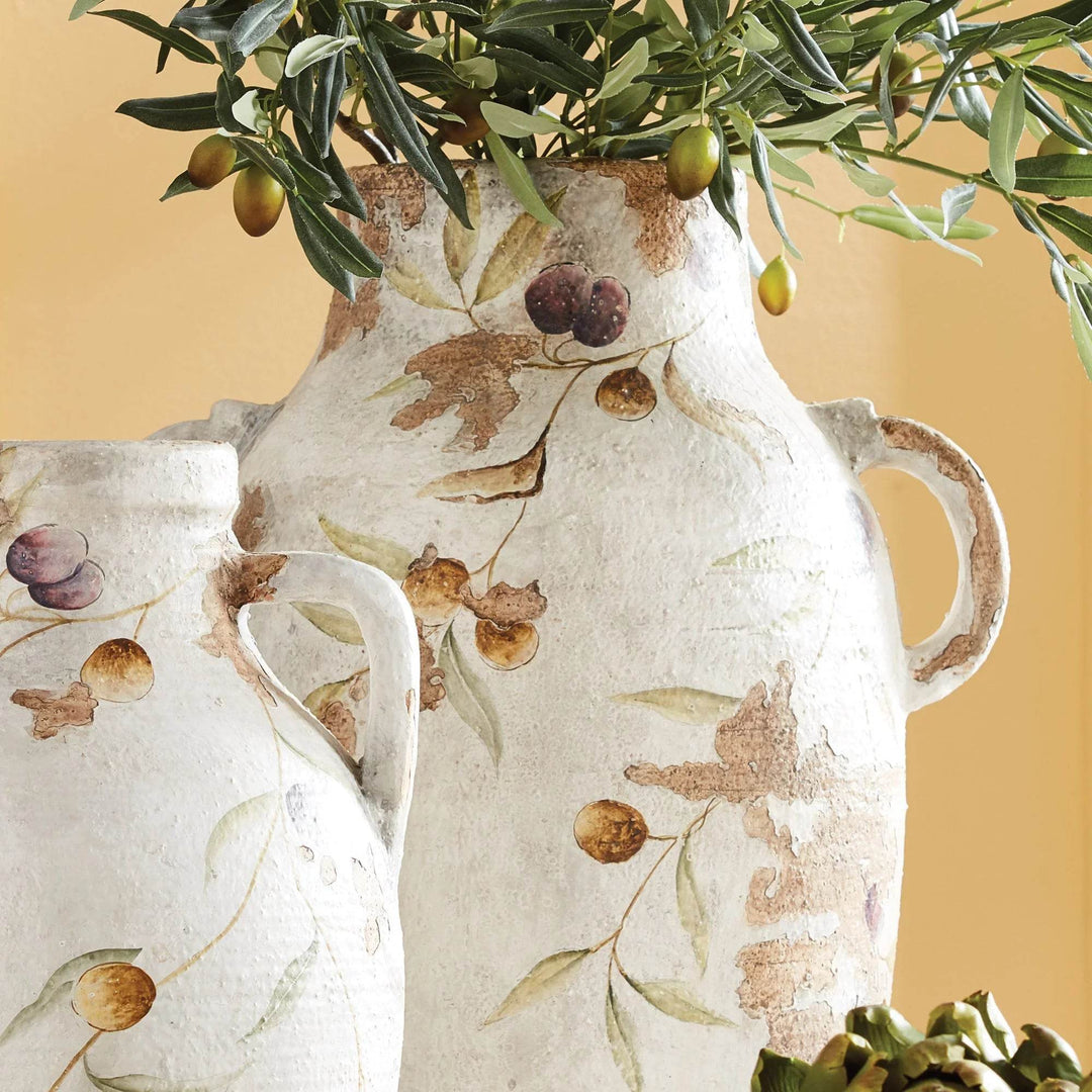 White ceramic handled pot styled with faux olive branches, highlighting its Italian-inspired hand-painted vine motif.