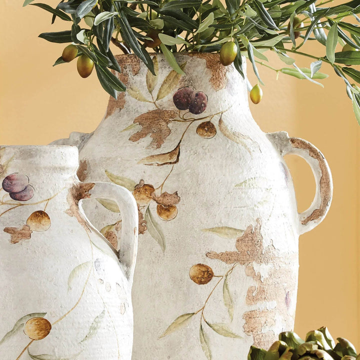White ceramic handled pot styled with faux olive branches, highlighting its Italian-inspired hand-painted vine motif.