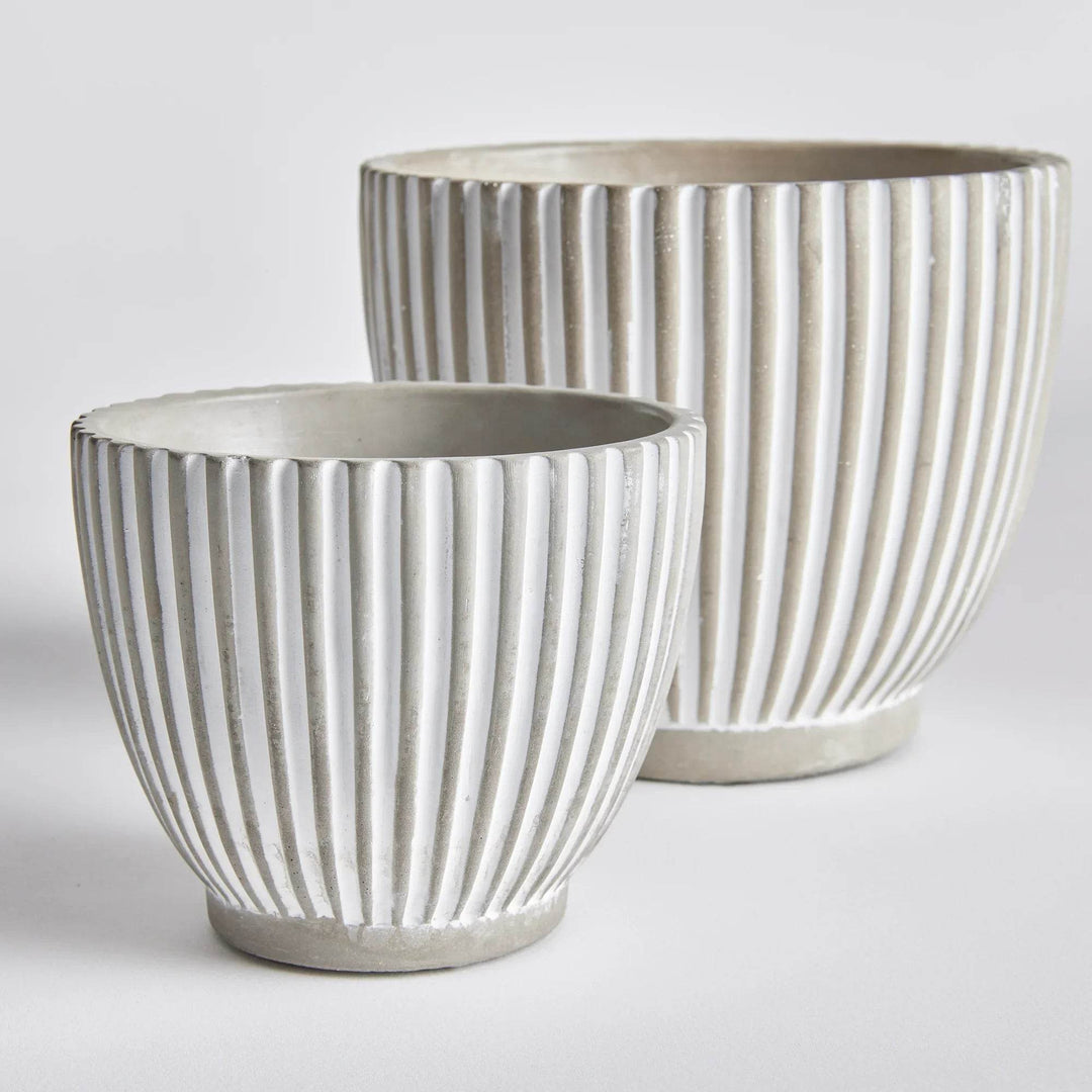 Set of two white concrete planter pots with vertical ribbed texture and tapered bases, shown together for scale – Modern Organic.