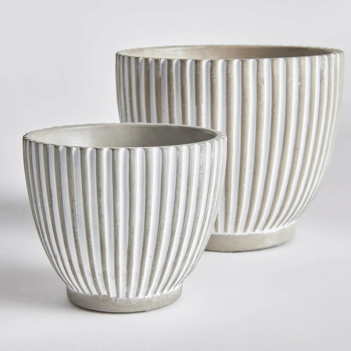 Set of two white concrete planter pots with vertical ribbed texture and tapered bases, shown together for scale – Modern Organic.