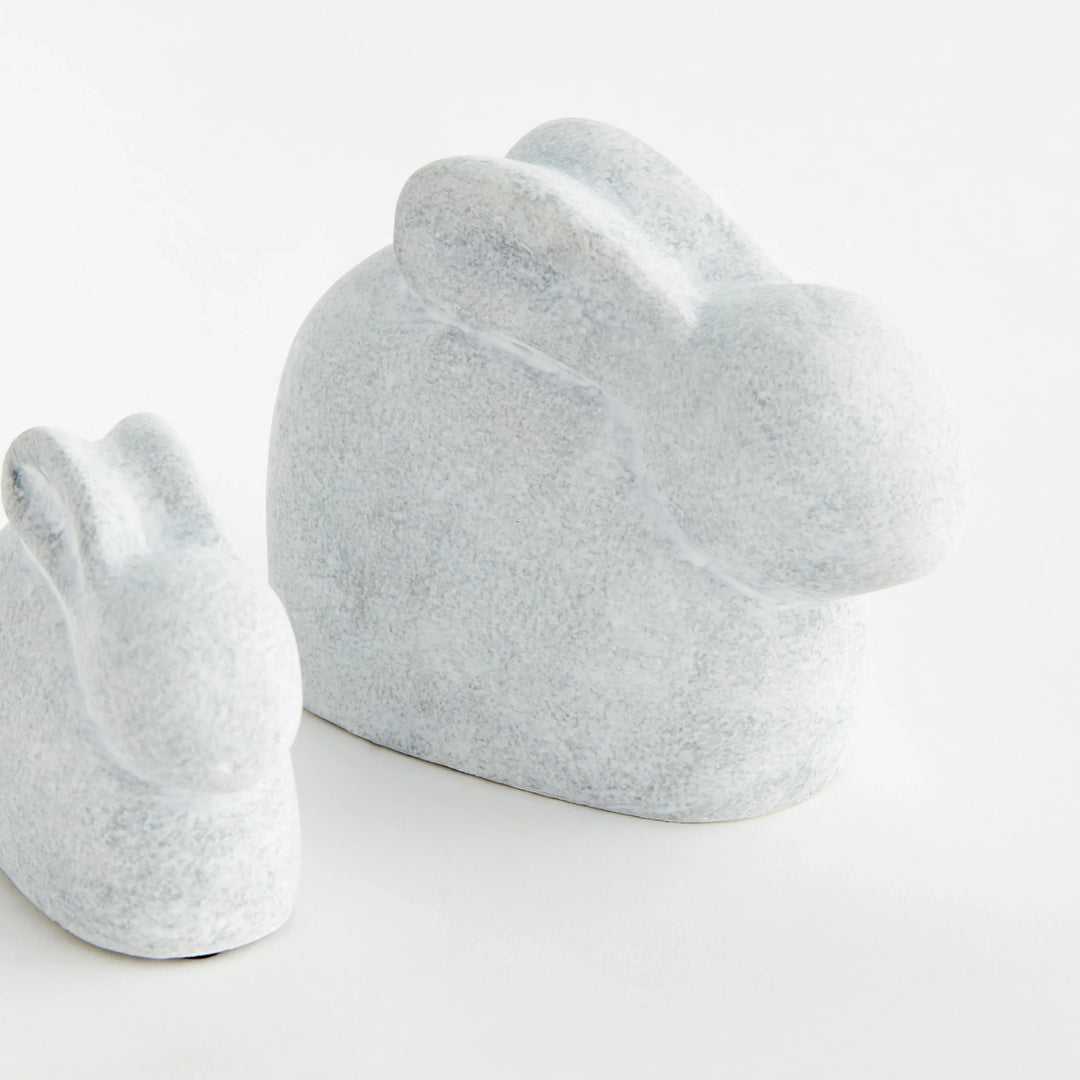 Set of two white concrete rabbit sculptures shown from the rear with rounded silhouettes and graywashed finish – Modern Organic.