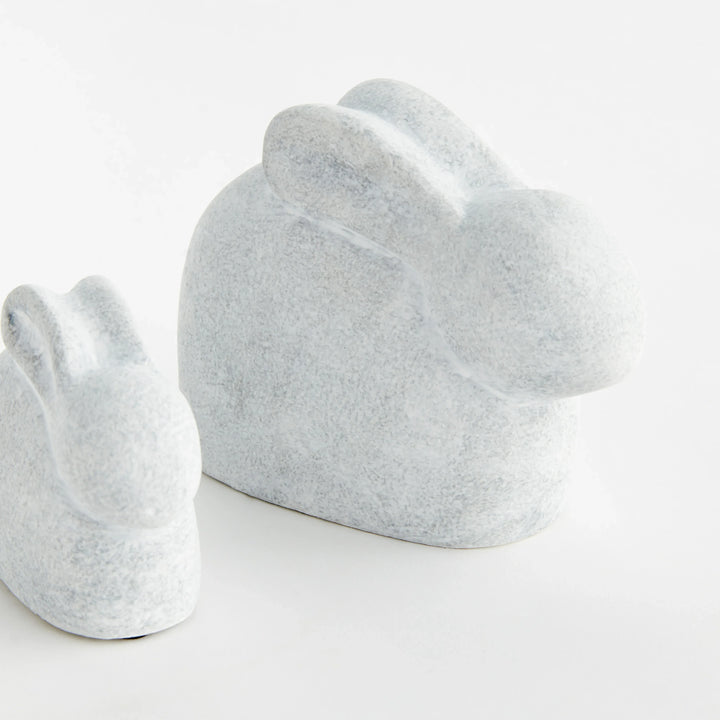 Set of two white concrete rabbit sculptures shown from the rear with rounded silhouettes and graywashed finish – Modern Organic.