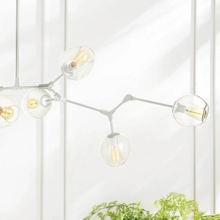 White chandelier branch close-up with adjustable joints and clear glass globes beside bright window, Mid-Century Modern style