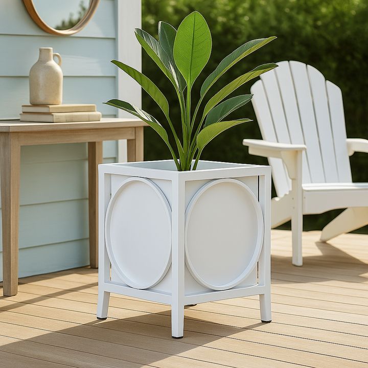 White modern coastal planter placed beside a stone garden path with tropical foliage and bright outdoor light.