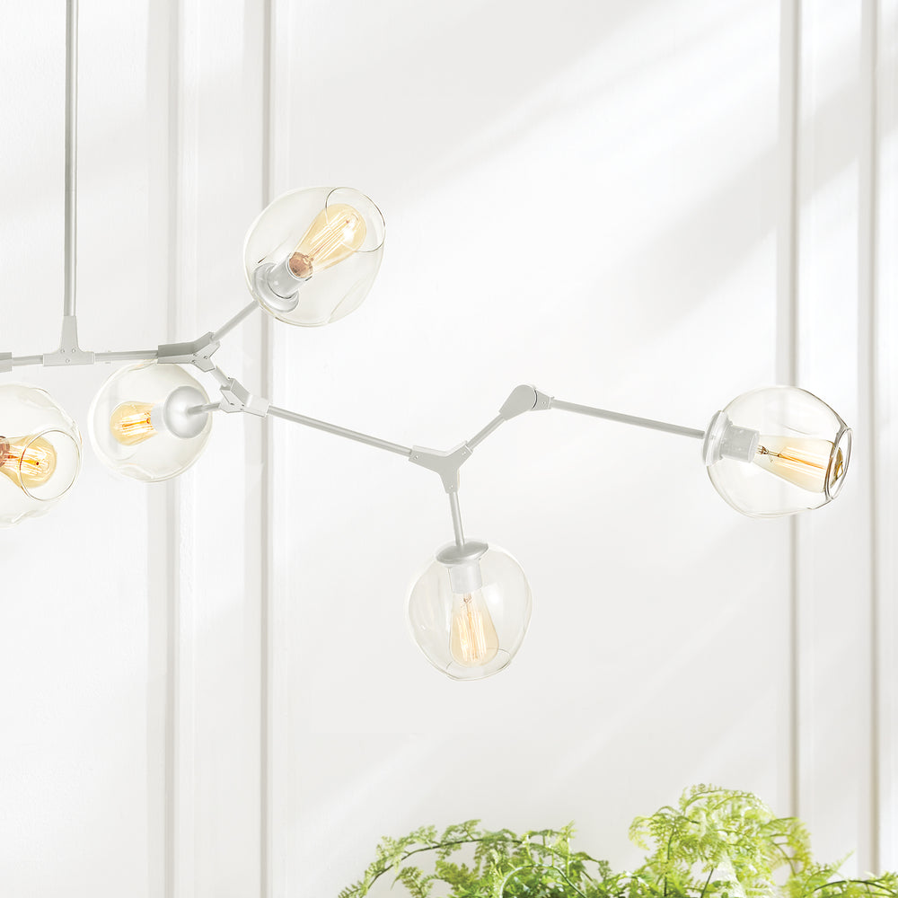 Close-up of white mid-century chandelier with clear glass globes and exposed filament bulbs.
