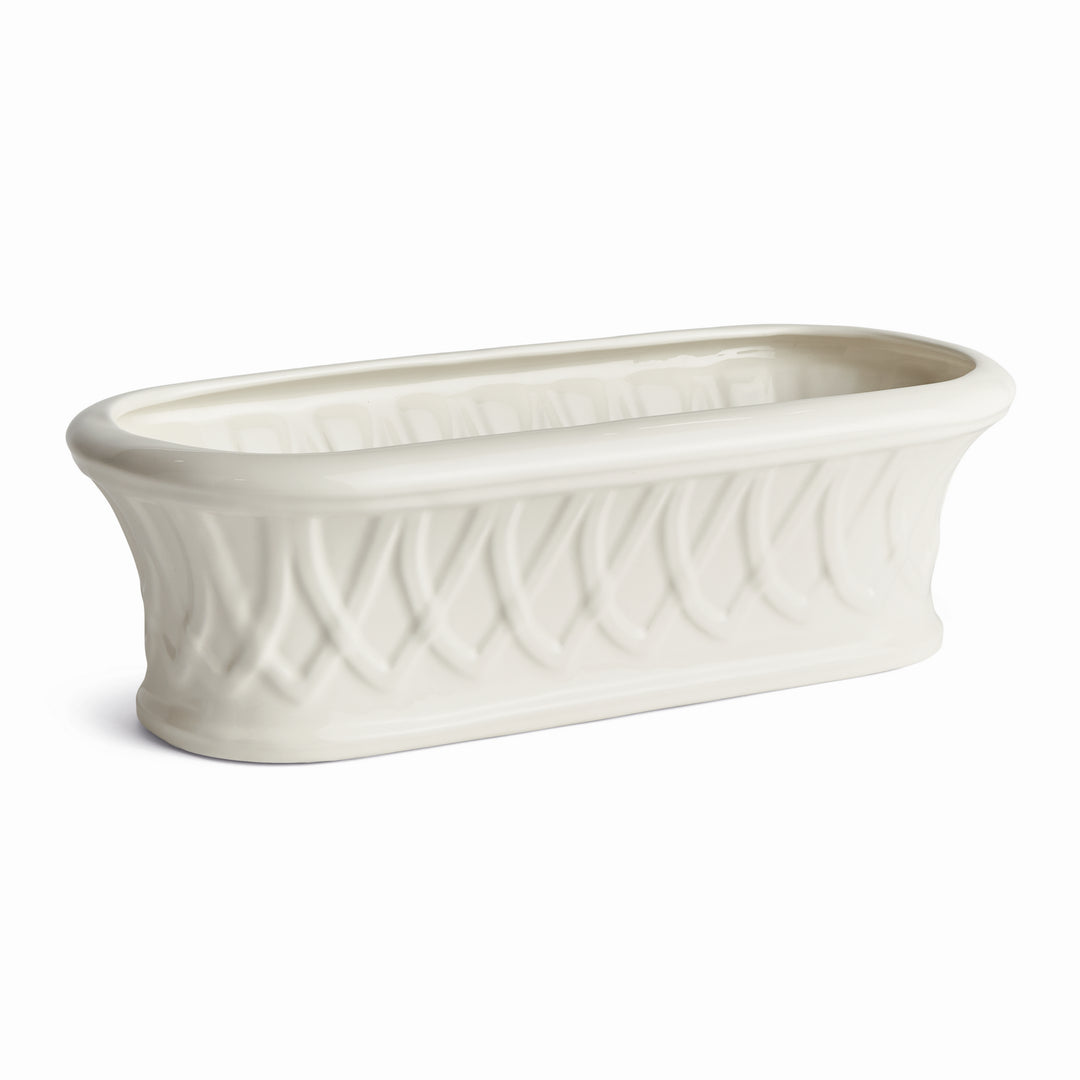 White oblong ceramic cachepot with raised basket-like relief, a flared rim and rounded ends, shown on white, Traditional