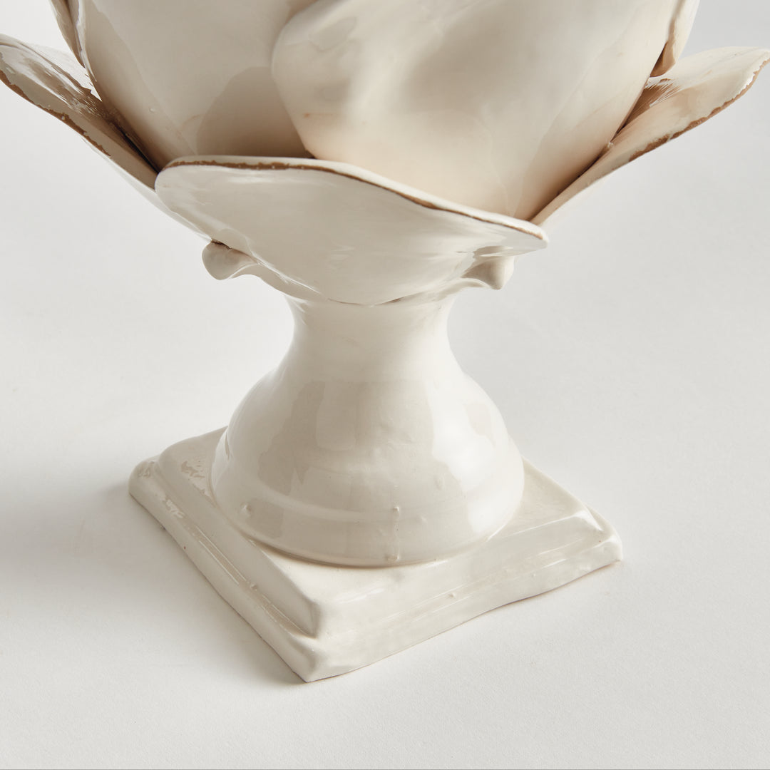 Detail of a white ceramic finial pedestal and square base, showing the softly antiqued finish against white, Traditional