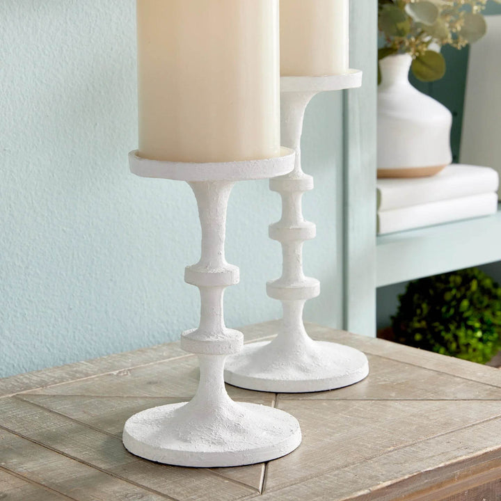 Set of two white pillar candle stands on a console table with greenery and wall art, slim profile and stable base design – Modern Farmhouse.